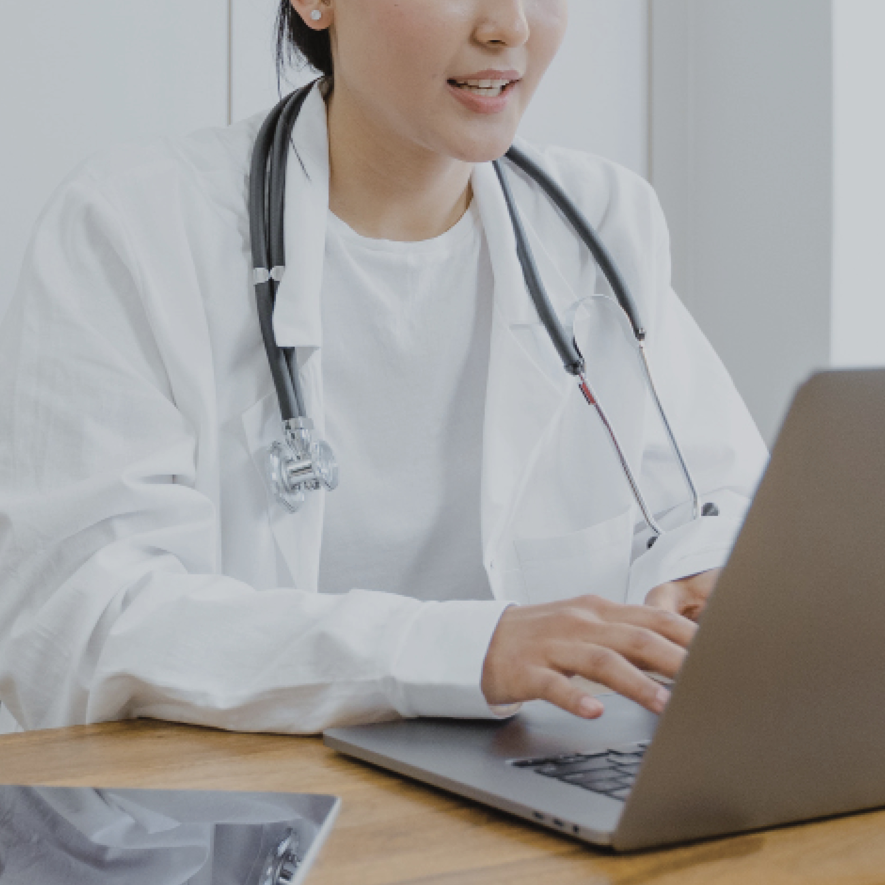 Photo of doctor typing on laptop