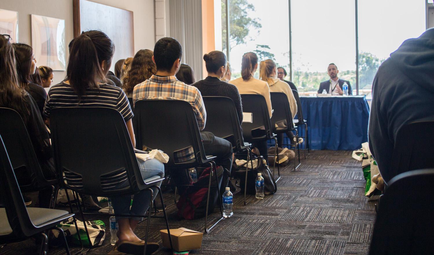 photo of audience of UCSB students watching panel of speakers