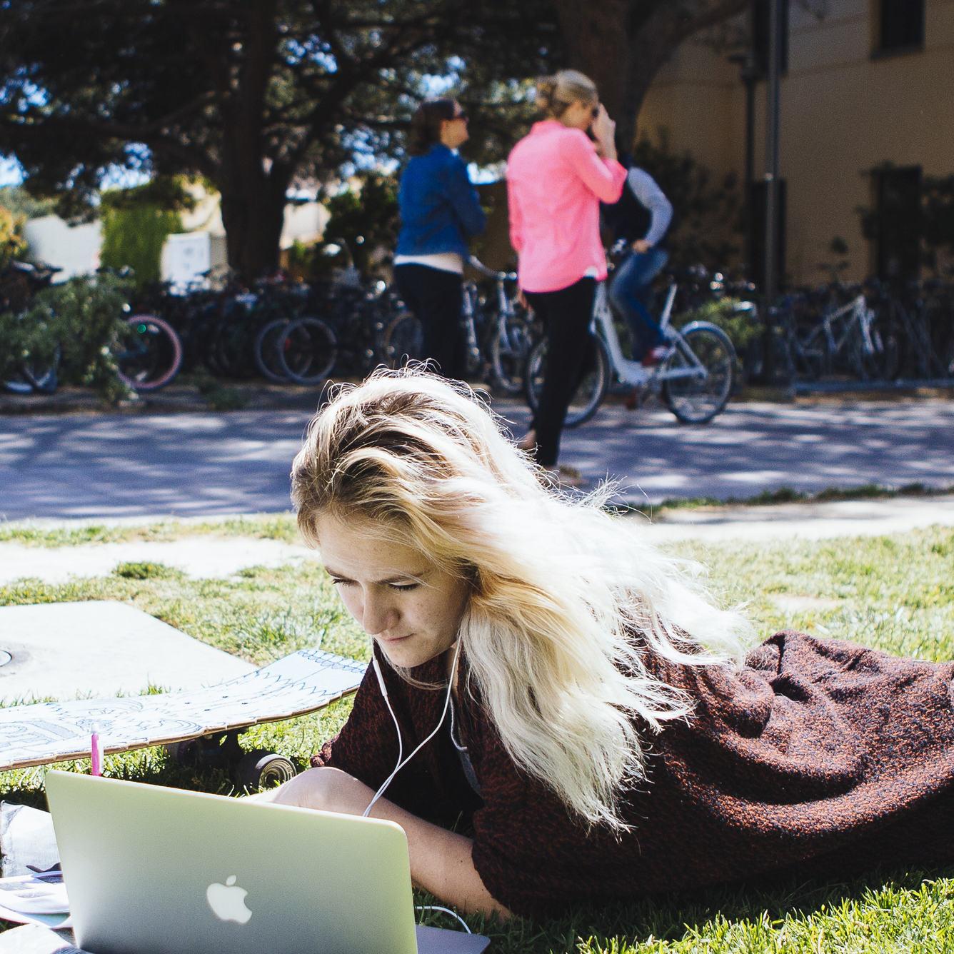 Student studying on lawn