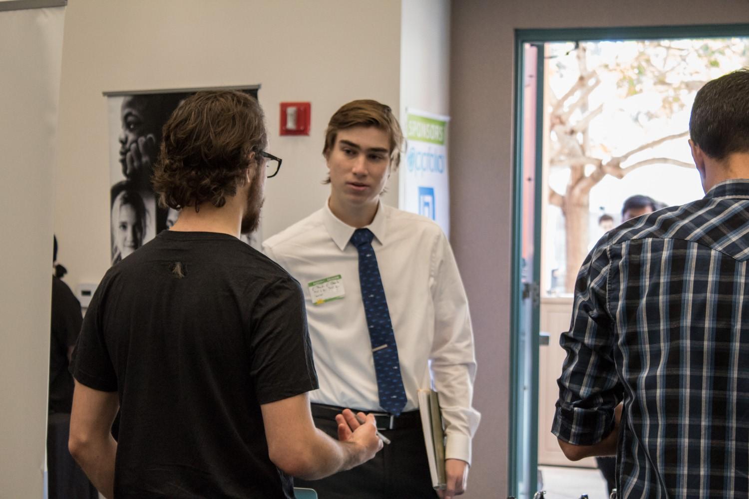 [photo of UCSB student interviewing at career fair for interviews and offers